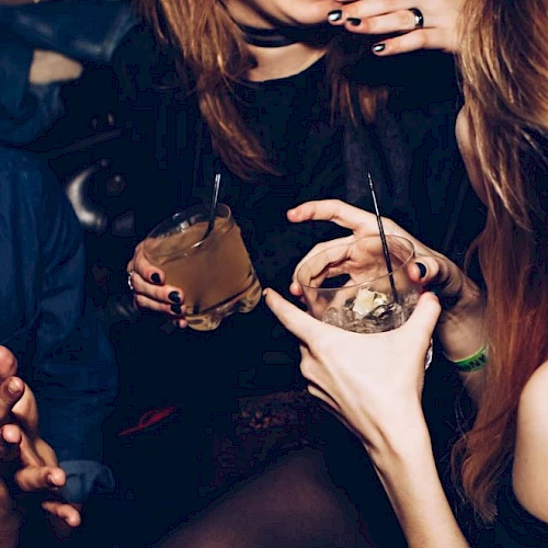 People are enjoying drinks and laughing, possibly at a social event or party.