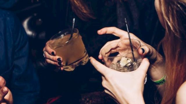 People are enjoying drinks and laughing, possibly at a social event or party.